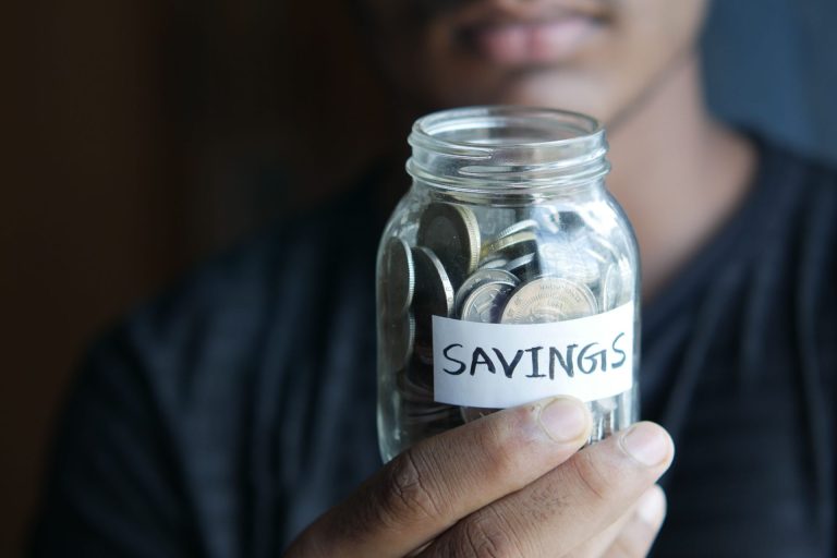 Person holding up savings jar